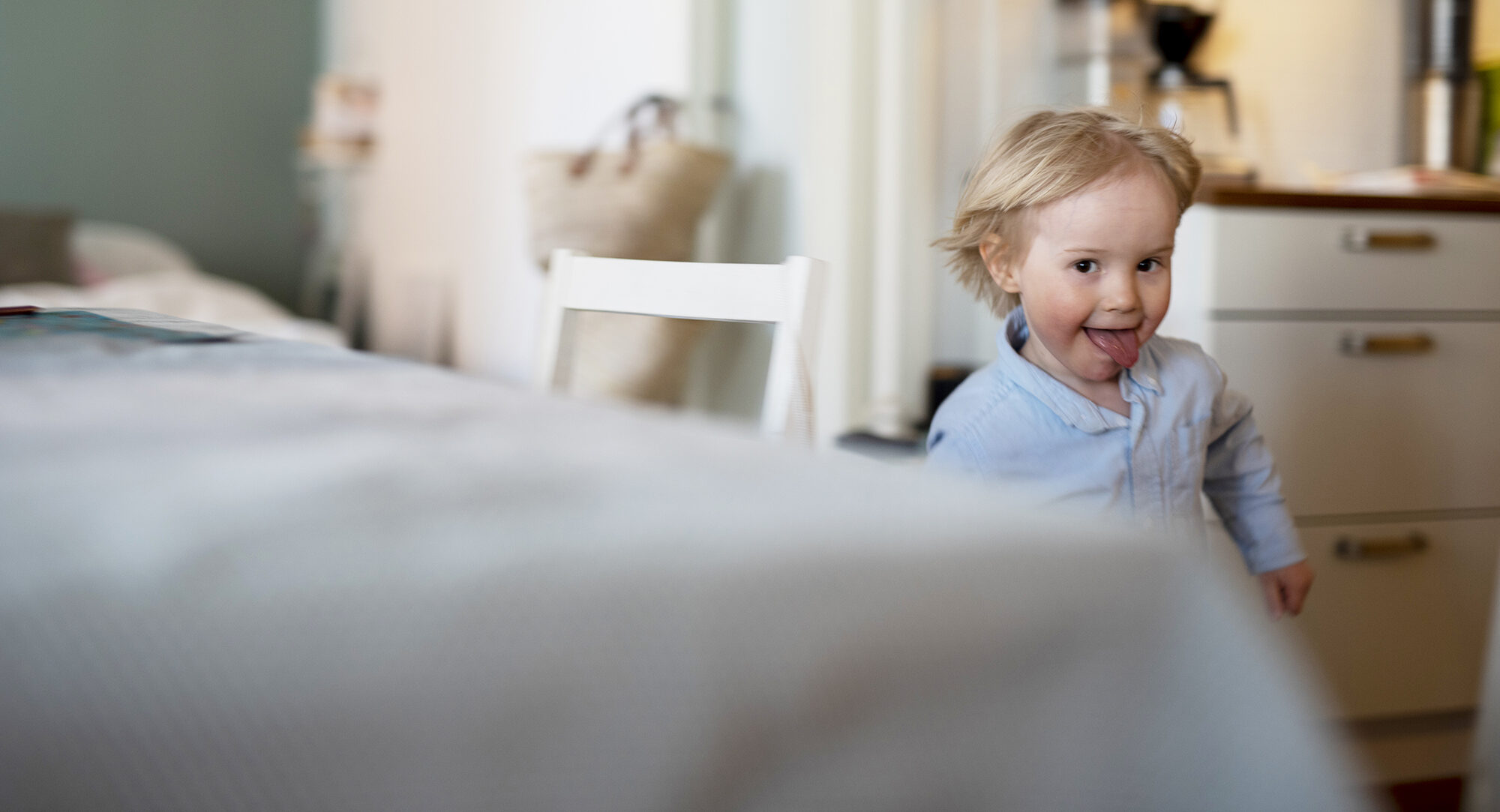 Lapsi juoksee keittiössä kieli ulkona.