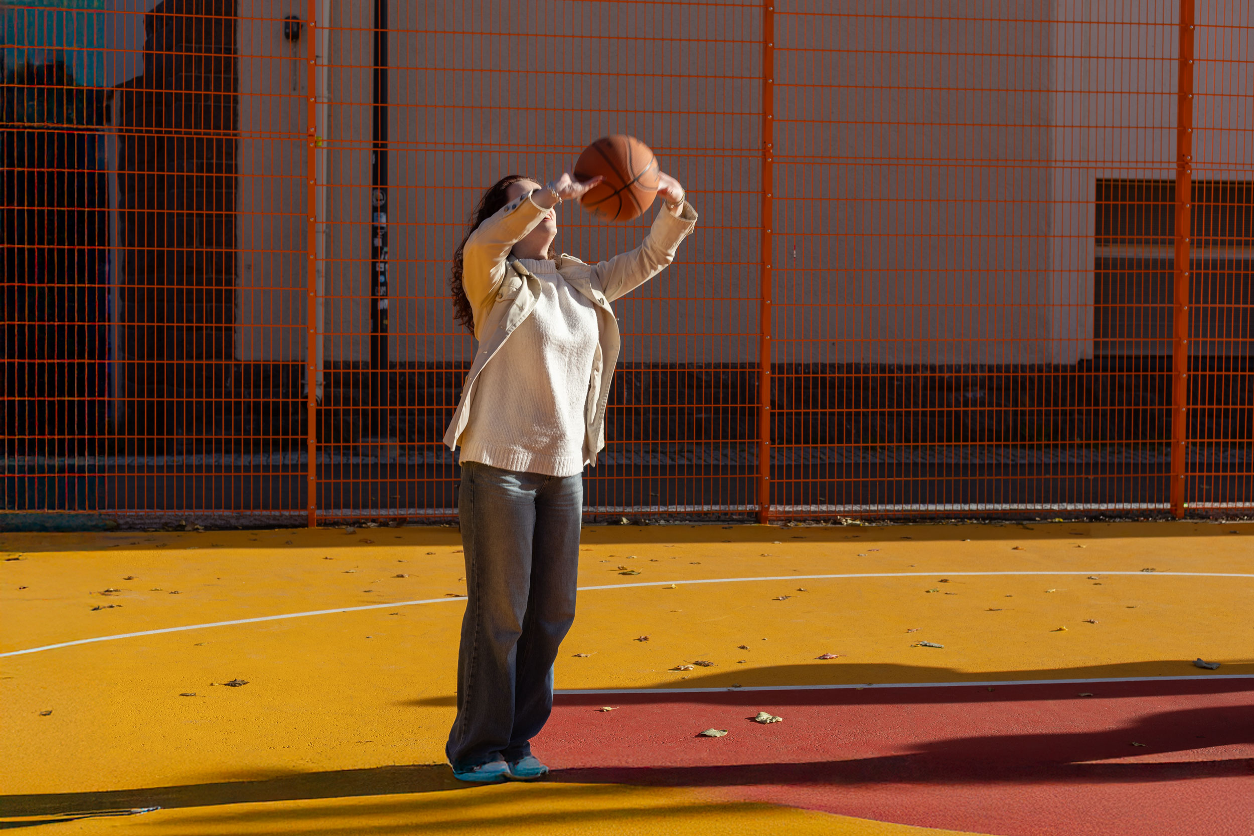 Nuori heittää koripalloa keltaisella alustalla