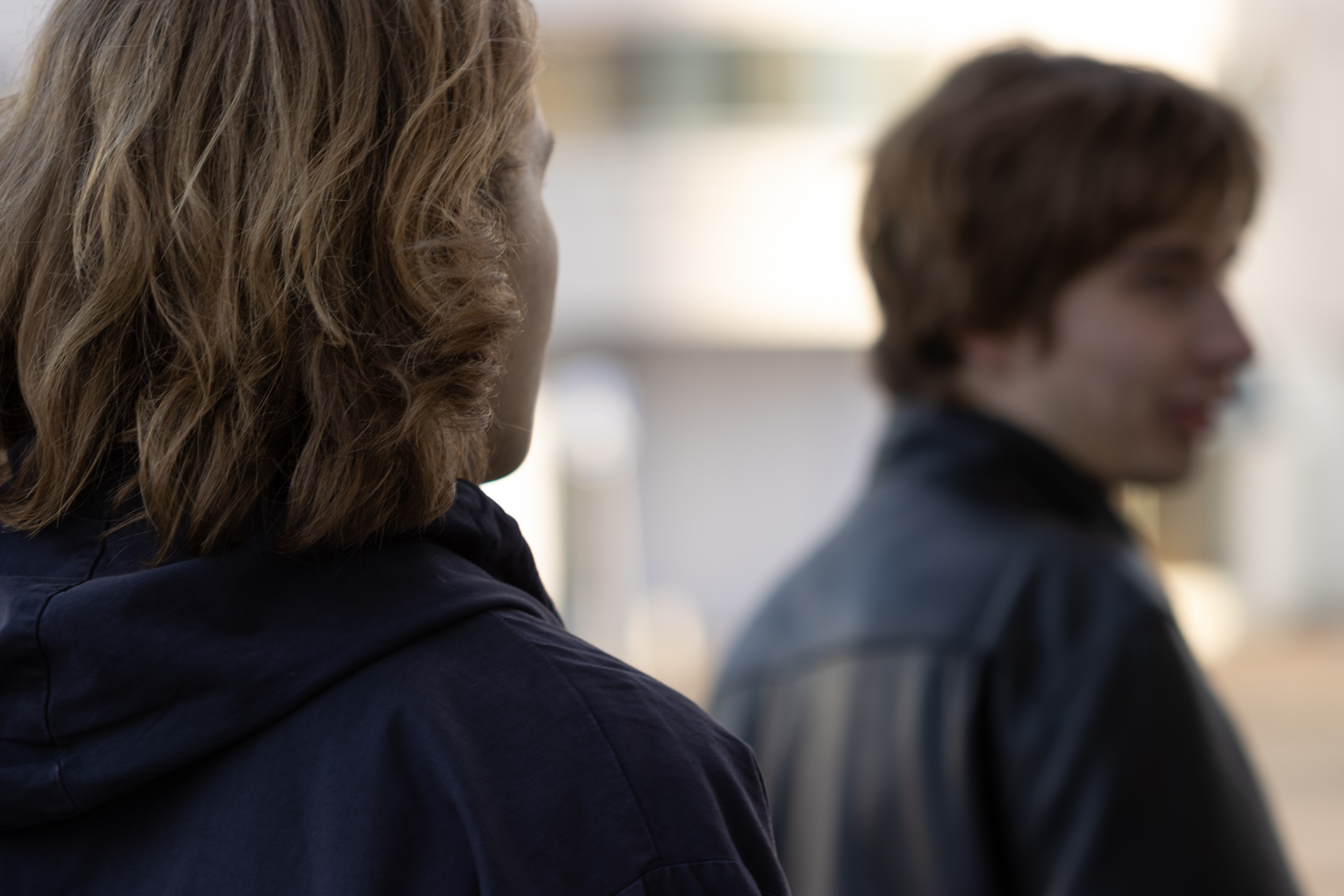 Kaksi nuorta ihmistä takaapäin kuvattuna.